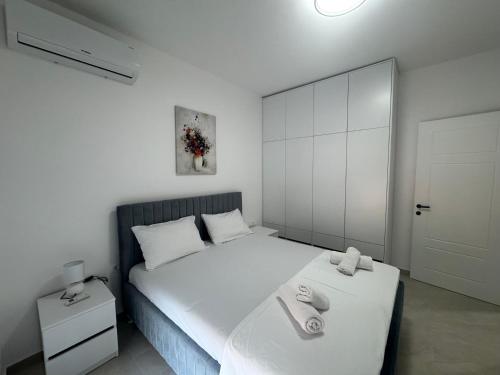 a bedroom with a white bed with towels on it at Prestige Lux Apartment in Bijela Glavica