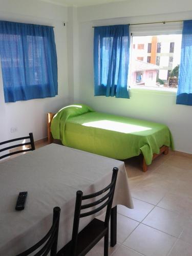 a room with two beds and a table and a window at Punta Gesell in Villa Gesell