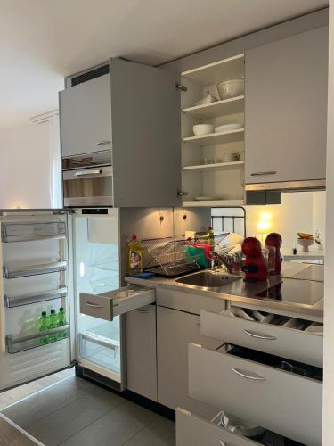 a kitchen with an open refrigerator and a sink at Harderkulm in Interlaken