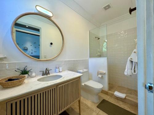 a bathroom with a sink and a toilet and a mirror at Verdaad Mansion in La Libertad