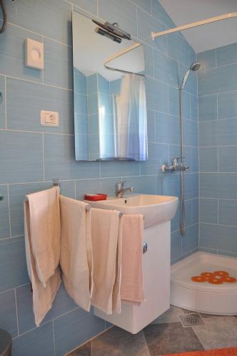 a bathroom with a sink and a mirror and towels at Apartment Stomorska in Stomorska