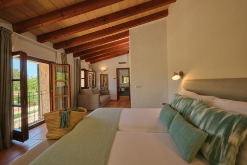 a bedroom with a large bed and a living room at Hotel Rural Es Riquers in Porreres