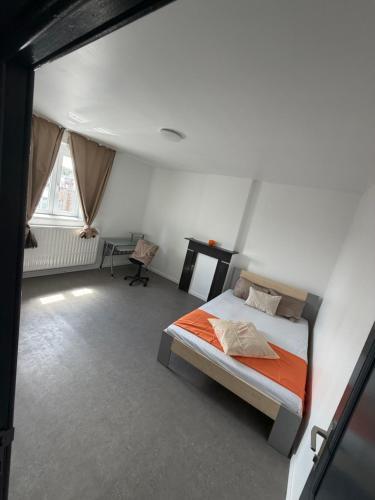 a bedroom with a bed and a desk in it at Ans soleil in Ans