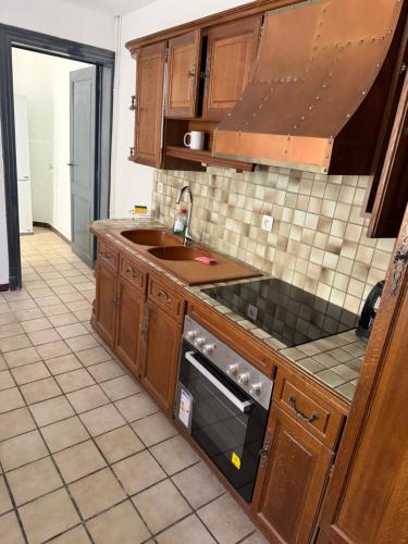 a kitchen with a sink and a stove at Ans soleil in Ans