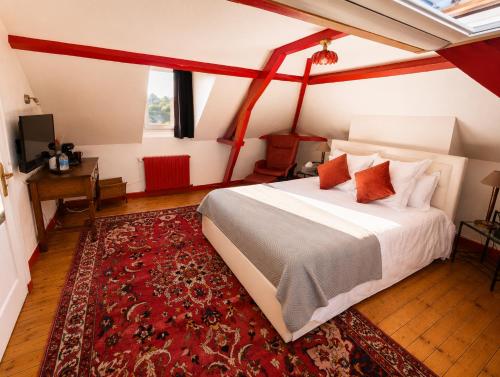 a bedroom with a large bed and a red rug at La Cour Du Puits Chambre Rooibos in Cormeilles