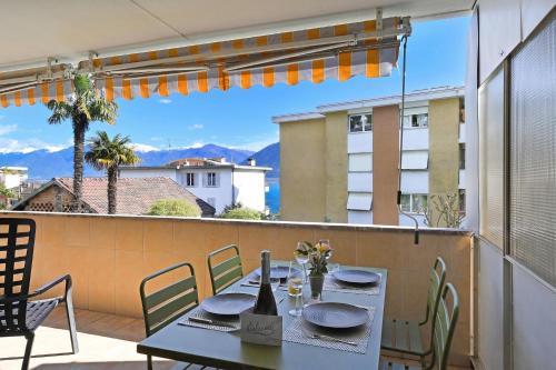 a table and chairs on a balcony with a view at Malibu46 - Minusio Apt with Shared Pool & Balcony - Happy Rentals in Minusio