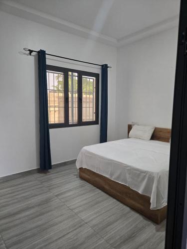 a white room with a bed and a window at Villa Princess Goofy in Lomé