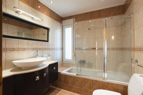 a bathroom with a sink and a shower and a tub at Maisonette ELINA in Corfu