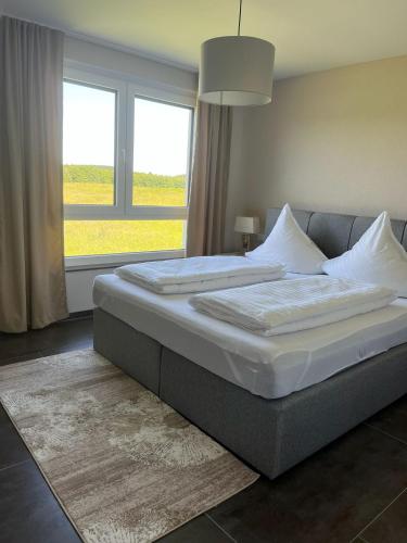 a large bed in a bedroom with a large window at Apartment by Ela in Alpirsbach