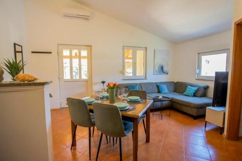 a living room with a table and a couch at Casa Oliva Kim Marie /w Garden - Happy Rentals in Medulin