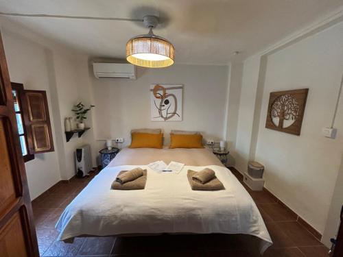 a bedroom with a large bed with two pillows on it at Casa La Nuez in Almedinilla