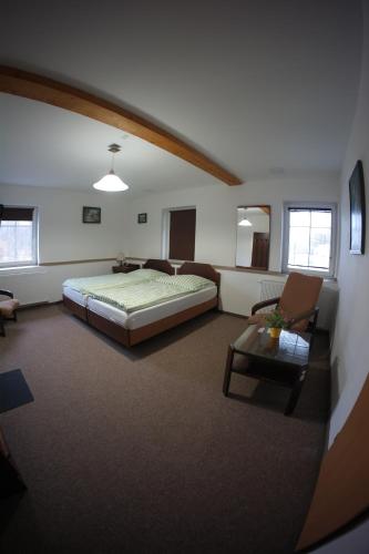 a bedroom with a bed and a couch and a table at Penzion Černý mlýn in Březová