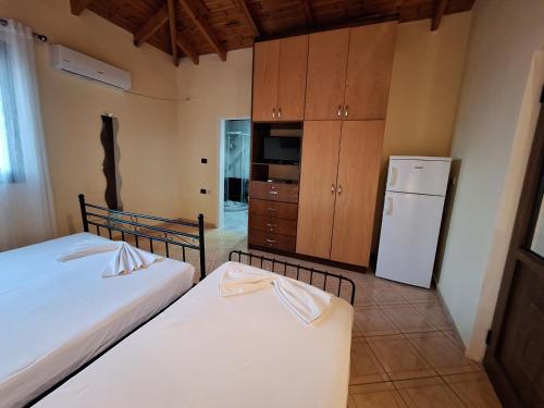 a bedroom with two beds and a refrigerator at Jannis Castle Apartment in Himare