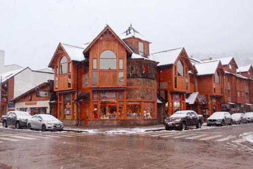 a large building with cars parked in a parking lot at Departamentos - Belgrano 810 in San Martín de los Andes