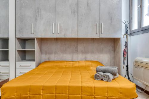 a bedroom with a yellow bed with white cabinets at Alessia House in Ferrara