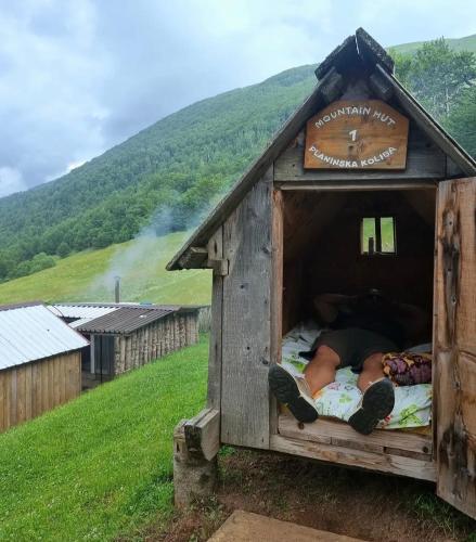 a person laying in a bed in a dog house at Katun Lanista-Kolibe Bogavac in Mojkovac