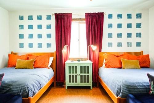 two beds in a room with red curtains at Family Fun Indoor Play Zone UP Waterfalls in Bessemer