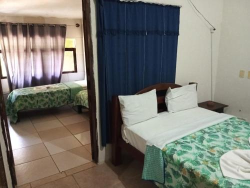 a hotel room with two beds and a mirror at Okakoaras Hotel in Paulista