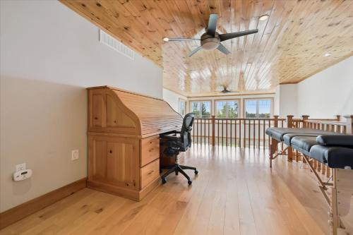 an office with a desk and a ceiling fan at Topaz Beach Cottage AC Waterview in Wiarton