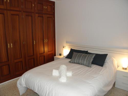 ヘレス・デ・ラ・フロンテーラにあるApartamento en Jerez de la Frontera 2のベッドルーム1室(白い大型ベッド1台、木製キャビネット付)