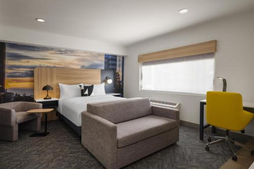 a hotel room with a bed and a chair at Aiden Hotel Sacramento Downtown in Sacramento