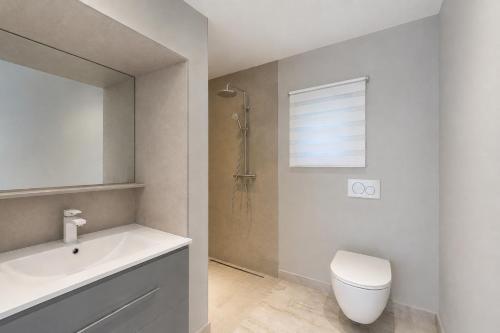 a bathroom with a white toilet and a sink at Villa Privée - Les Trois J - Charme & Bien-être in Grimaud