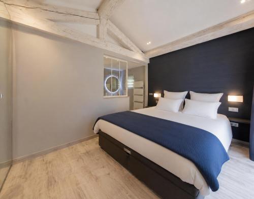 a bedroom with a large bed and a window at Villa Privée - Les Trois J - Charme & Bien-être in Grimaud