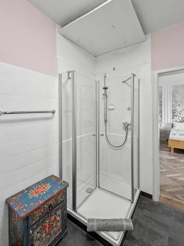 a shower stall in a bathroom with a stool at Landhaus Schönblick in Bad Kohlgrub