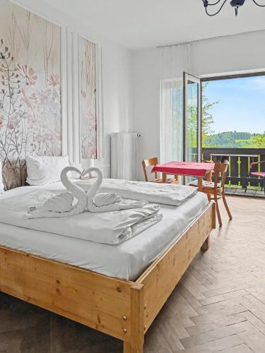 a bedroom with a bed with two swans on it at Landhaus Schönblick in Bad Kohlgrub