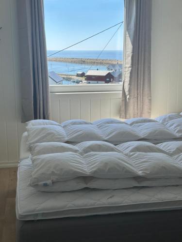 a bed in a room with a large window at Ocean panorama in Farsund