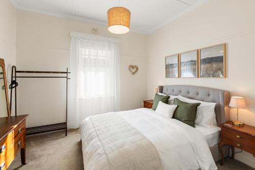 a bedroom with a large bed with green pillows at Queenie's Cottage in Mansfield