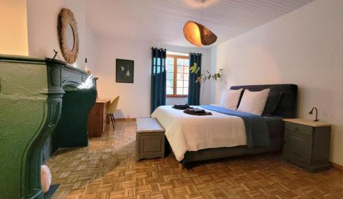 a bedroom with a bed and a desk in it at La petite Sorbonne - Chambres d'hôtes in Malleval
