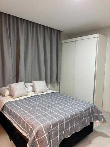 a bedroom with a bed with a blue and white blanket at Residencial Bom Sossego Apto 01 in Itabuna