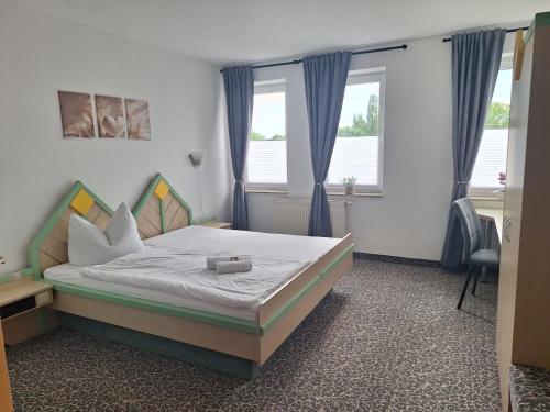 a bedroom with a bed and two windows at Hotel am Zellwald in Großschirma
