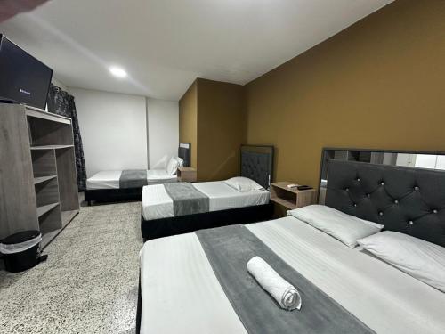 a hotel room with two beds in a room at hotel guayacanes central in Medellín