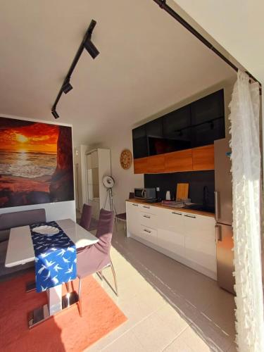 a kitchen with a table and chairs and a tv at Apartament Słoneczny in Skala Fourkas