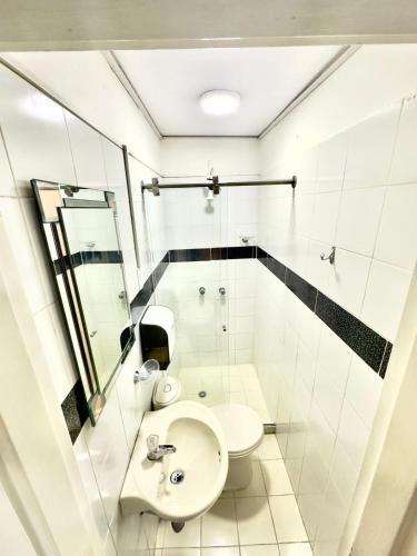 a bathroom with a sink and a toilet at hotel guayacanes central in Medellín