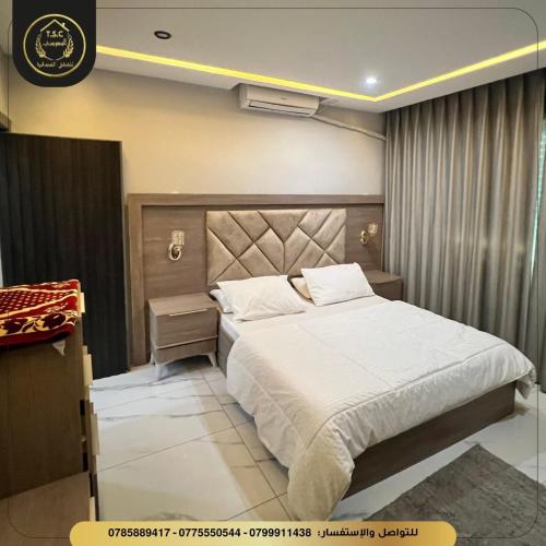 a bedroom with a large white bed in a room at السعودي للشقق الفندقيه in Az Zarqa