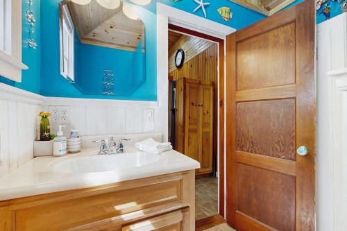 a bathroom with a sink and a wooden door at Sebago Shores Cottage in North Sebago