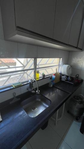 a kitchen counter with a sink and a window at Casa do Mascarenhas in Picos