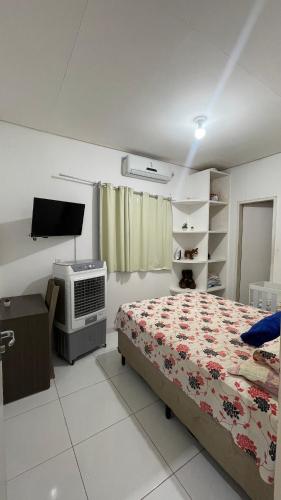 a bedroom with a bed and a tv in it at Casa do Mascarenhas in Picos