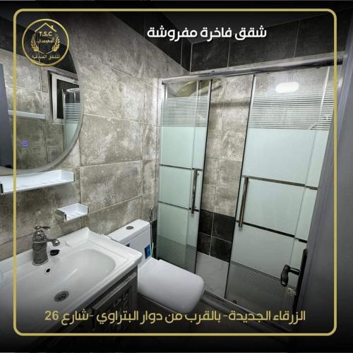 a bathroom with a sink and a mirror and a toilet at السعودي للشقق الفندقيه in Az Zarqa