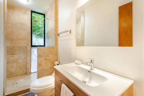 a bathroom with a sink and a toilet and a mirror at Beautiful private villa with an ecological pool in Santa Maria Huatulco