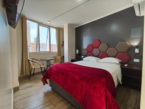 a bedroom with a large bed with a red blanket at Hospedaje Diamantes in Huacho