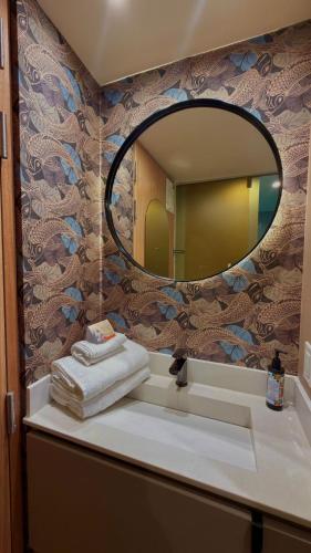 a bathroom with a mirror and a sink with towels at Hotel Oliver in Bogotá