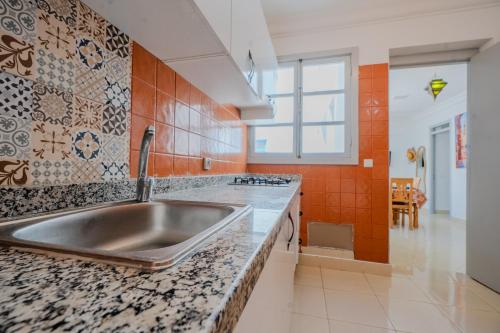 a kitchen with a large stainless steel sink at Dar Tilila in Essaouira