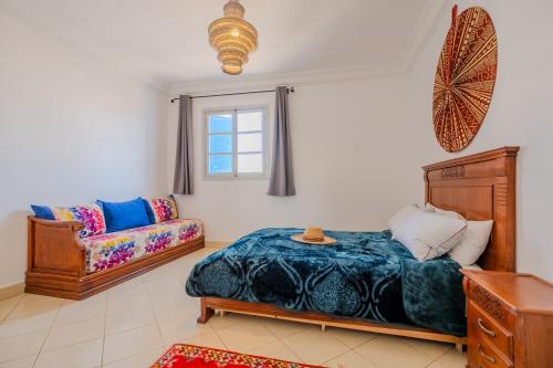 a bedroom with a bed and a couch at Dar Tilila in Essaouira