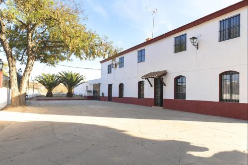 an empty parking lot in front of a white building at Casa Rural La Vega in Antequera