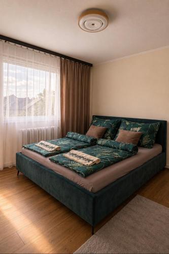 a large bed in a room with a window at Tófenék Deluxe Apartman in Szolnok
