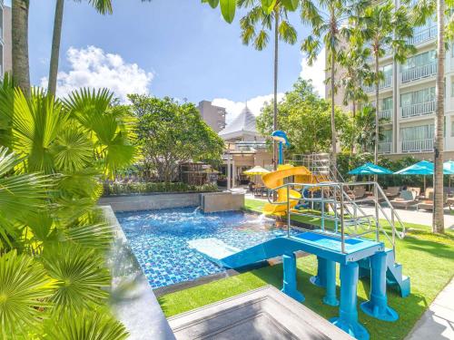 a pool with a slide and a playground at Grand Mercure Phuket Patong in Patong Beach
